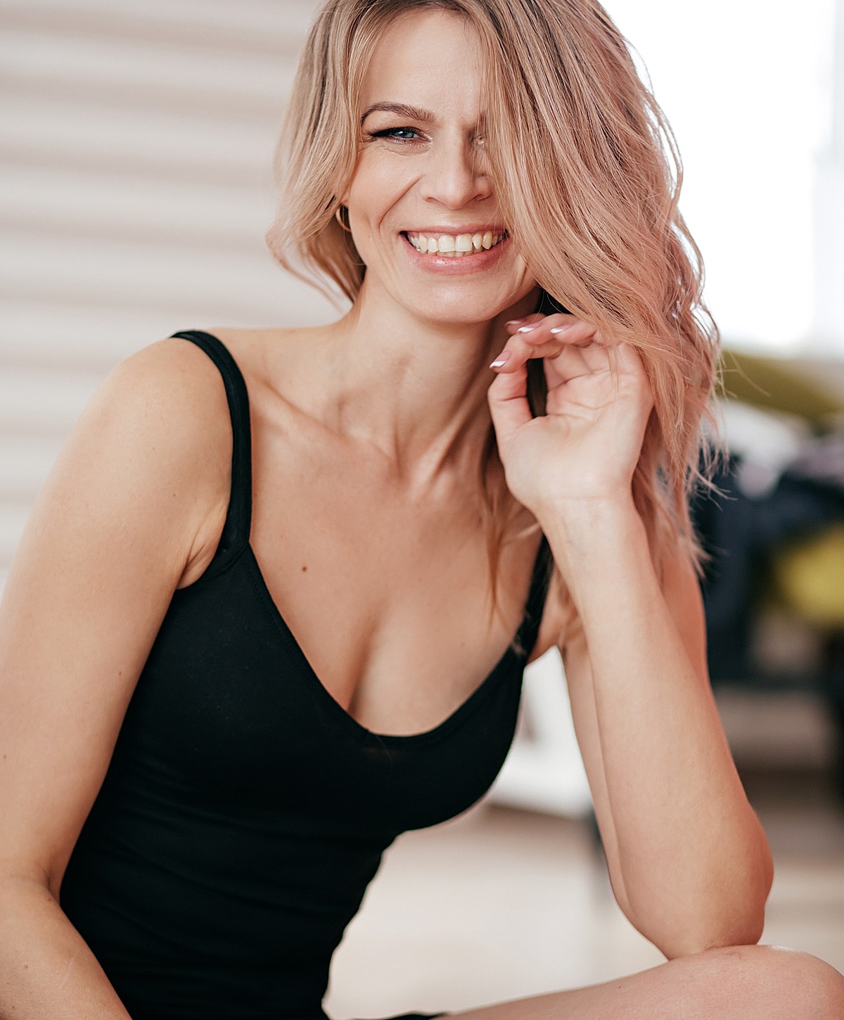 Tucson Breast Reduction model in black swimsuit posing confidently.