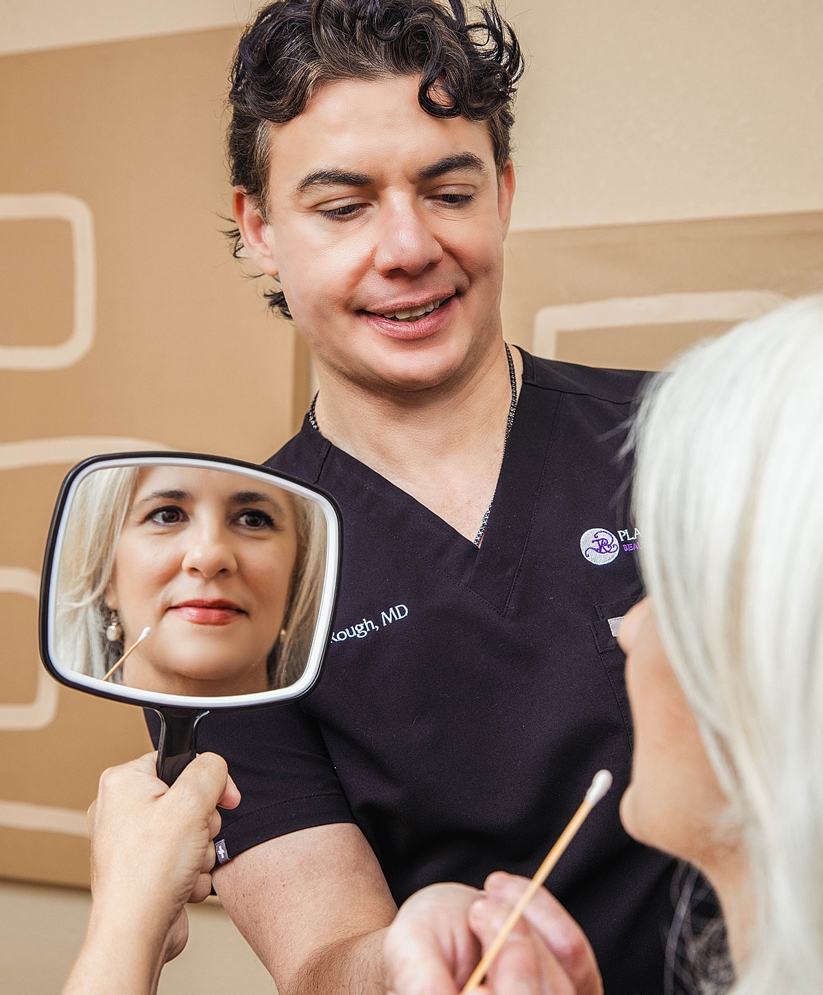 Tucson Facelift surgeon, James Rough consulting patient with mirror reflection.