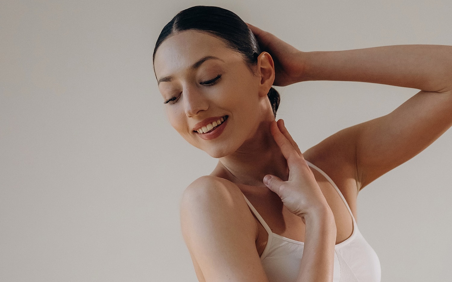 Smiling woman posing gracefully with soft lighting.